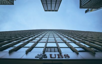 Low angle view of New York skyscrapers with UBS logo, emphasizing height and urban architecture.