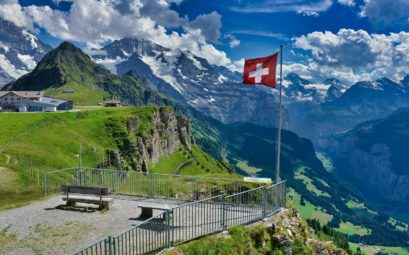 a flag on a pole in front of a mountain range